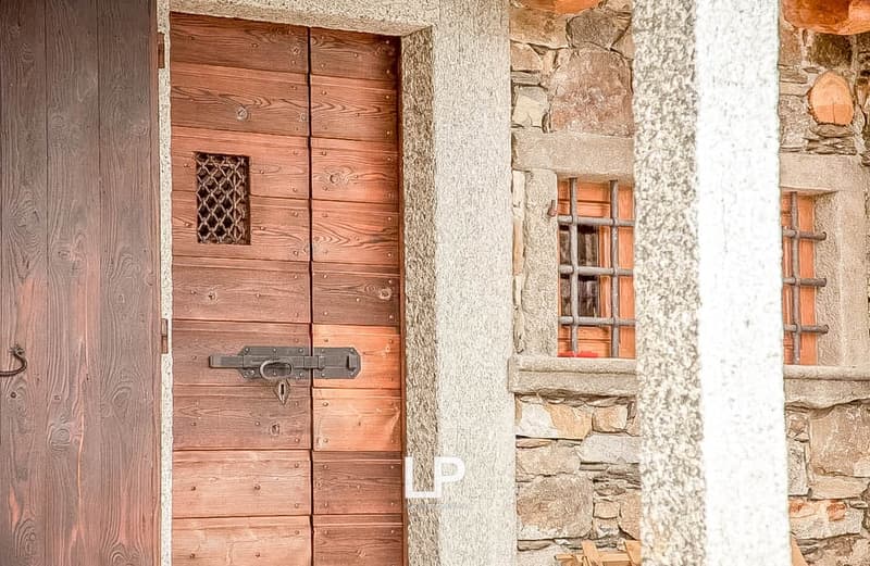Wooden entrance door, stone pillar, metal window grille