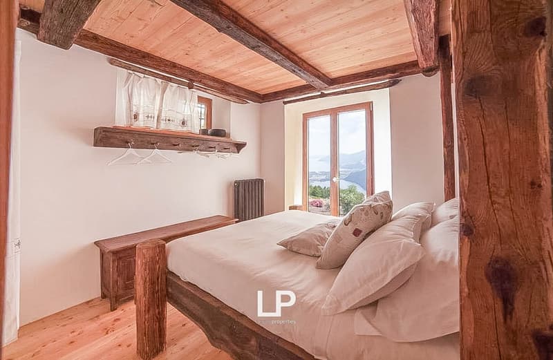 wooden beams, wooden floor, large window, large bed, wooden bench, radiator, wooden shelf, view