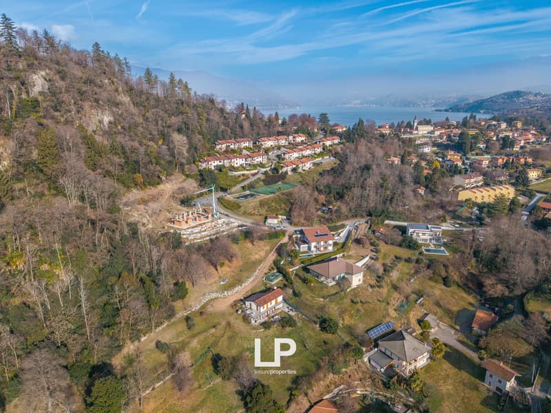 Countryside residential area with several houses, a tennis court, and solar panels