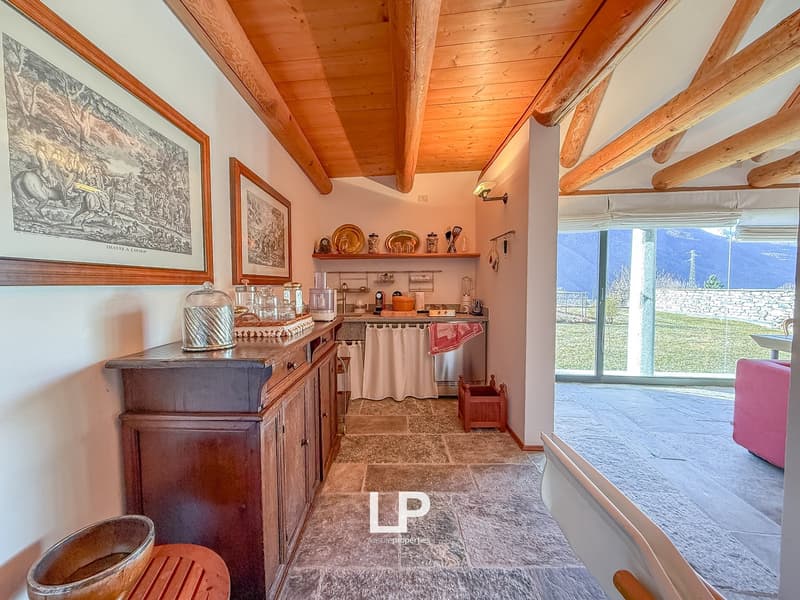 Wooden ceiling, white walls, countertop, drawers, glass door leading to a patio with a view