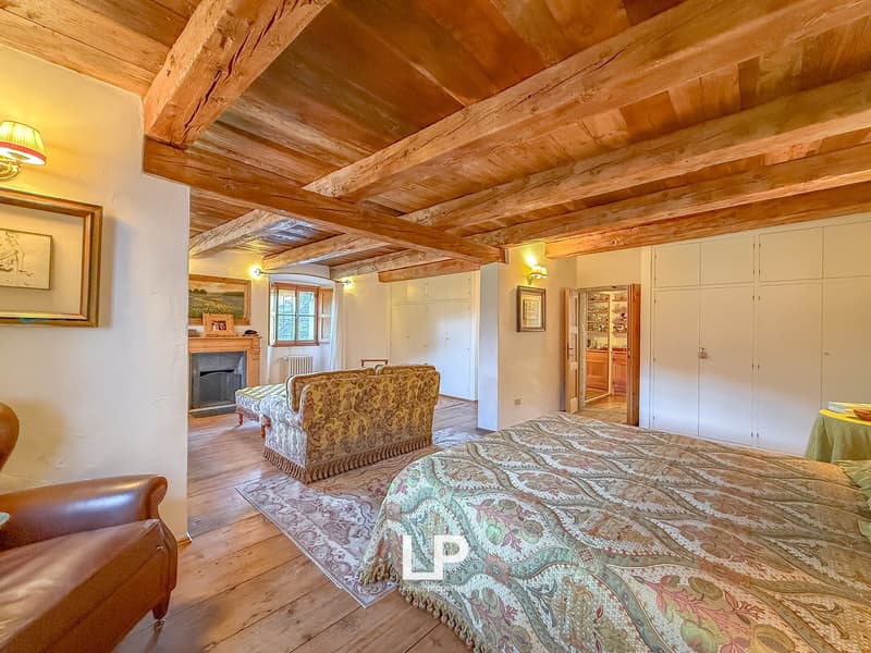 wooden beam ceiling, fireplace, couch, carpet, wooden floor, large bed, wardrobes, table with tablecloth