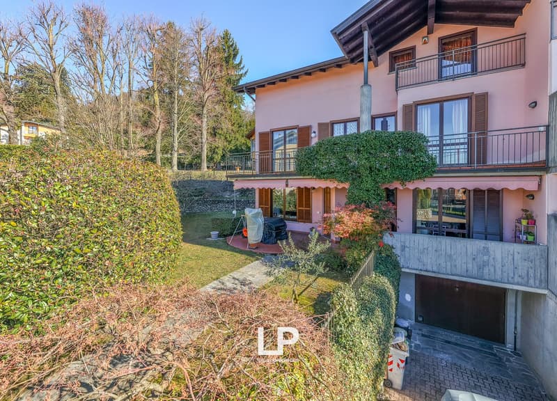 2 story house, pink paint, balcony, garage, large yard, trees