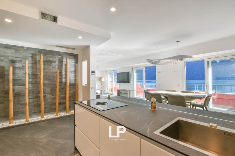 kitchen area with island, dining area with large windows, bamboo wall design, open layout, granite countertops, modern lighting, dining table and chairs, outdoor access to balcony