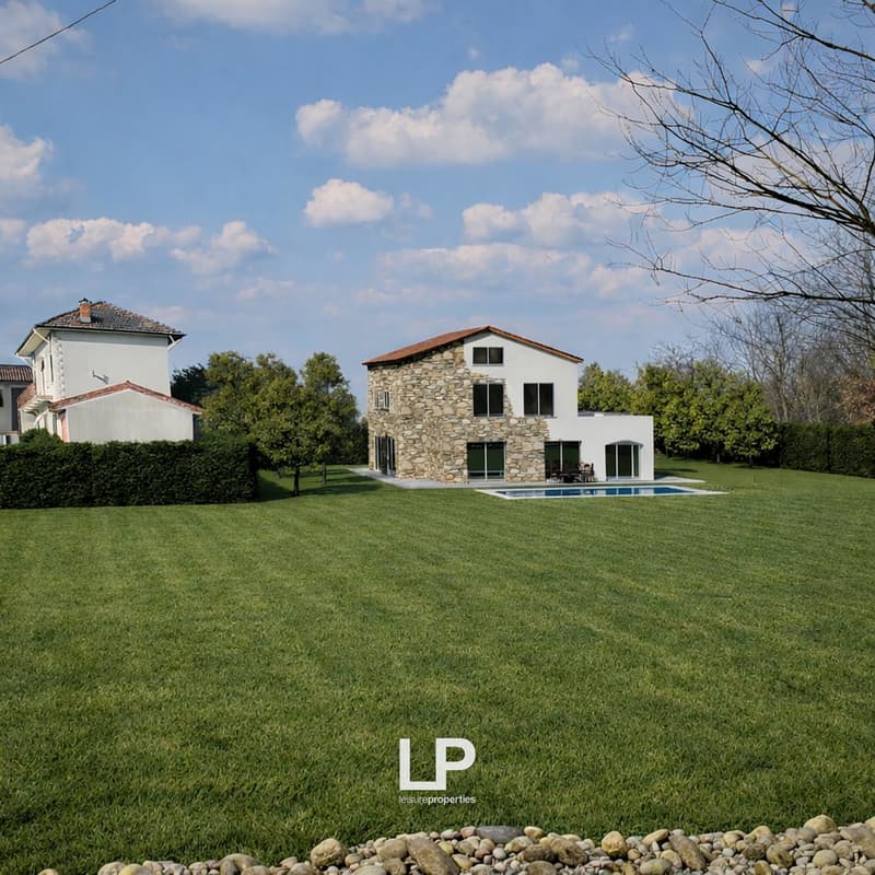 Stone house with a swimming pool, large lawn, trees, and a view