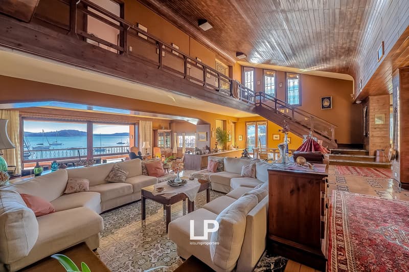 large living room, wooden ceiling, large windows, couches, coffee table, wooden cabinet, view of the sea