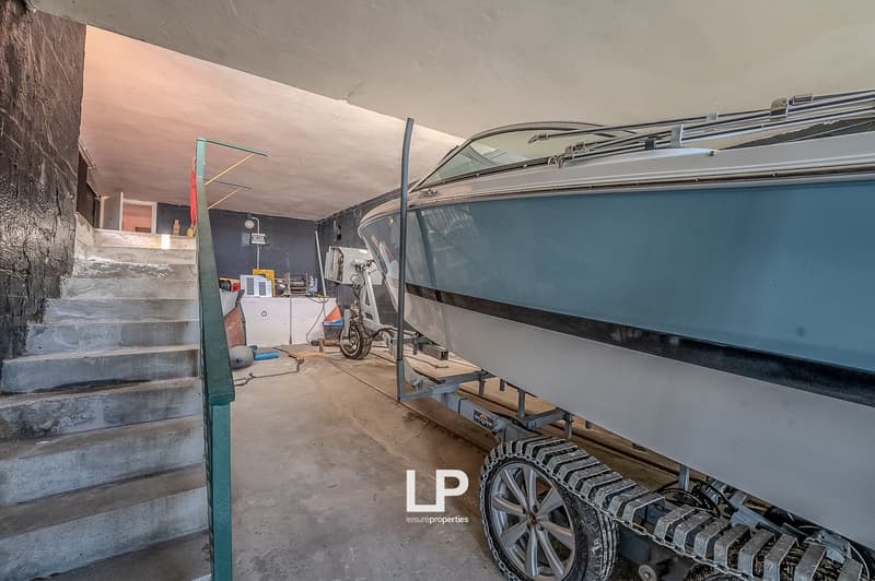 concrete stairs, boat on trailer, motorcycle, storage boxes, wall mounted lamp
