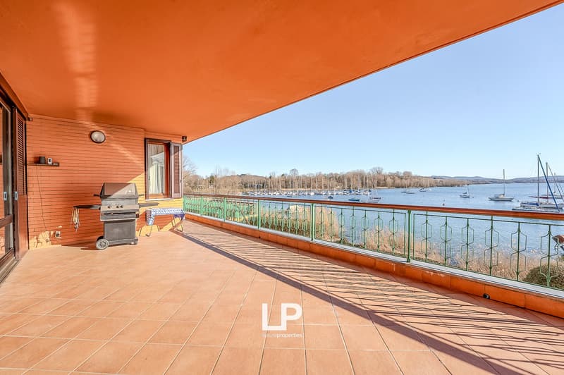 tiled floor, green railing, grill, table, lake view