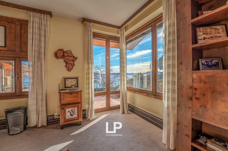 large windows, wooden floor, wooden furniture, decorative items, curtains, view of the sea