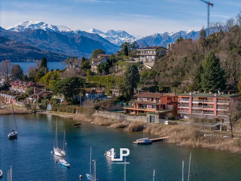Houses on a hillside with a lake and mountains in the background
