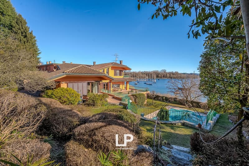 2 story house, yellow exterior, brown roof, swimming pool, lake view