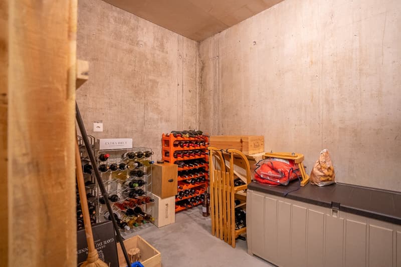 Wine cellar with wine racks, wooden storage boxes, and a wooden wine rack.