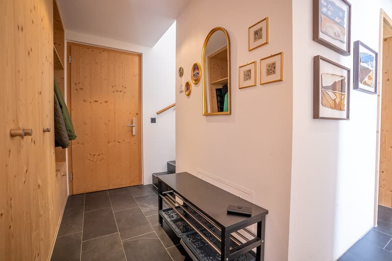 wooden door, wooden wall, tiled floor, mirror, bench, picture frames