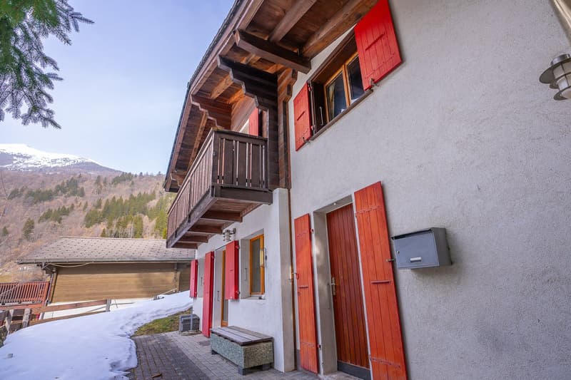 wooden balcony, red shutters, white walls, mailbox, snow on ground