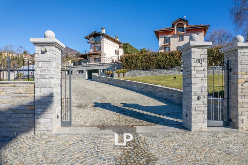 Cobblestone driveway, stone pillars, gated entrance, large house, garden, trees