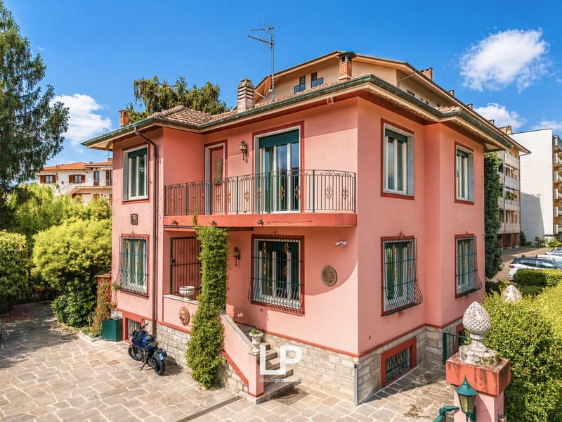 2 story house, pink exterior, red roof, balcony, staircase, motorcycle parked in front