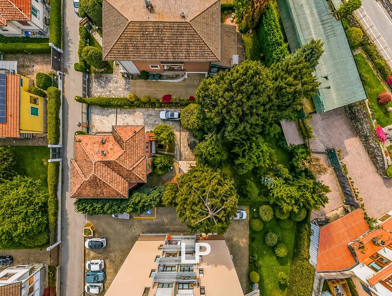 Aerial view of a neighborhood with multiple houses, driveways, and parking spaces.