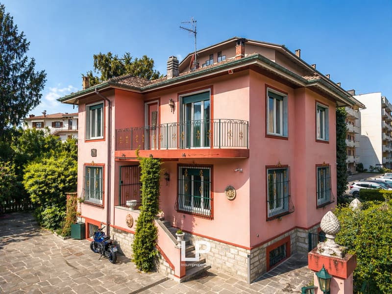 3 story house, pink exterior, green windows, balcony, staircase, motorcycle parked in front