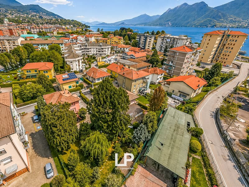 Aerial view of a town with many buildings, mountains, and a lake in the background