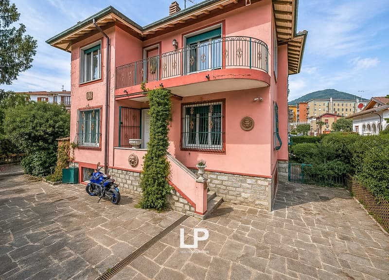 2 story house, pink exterior, balcony, staircase, motorcycle parked in front