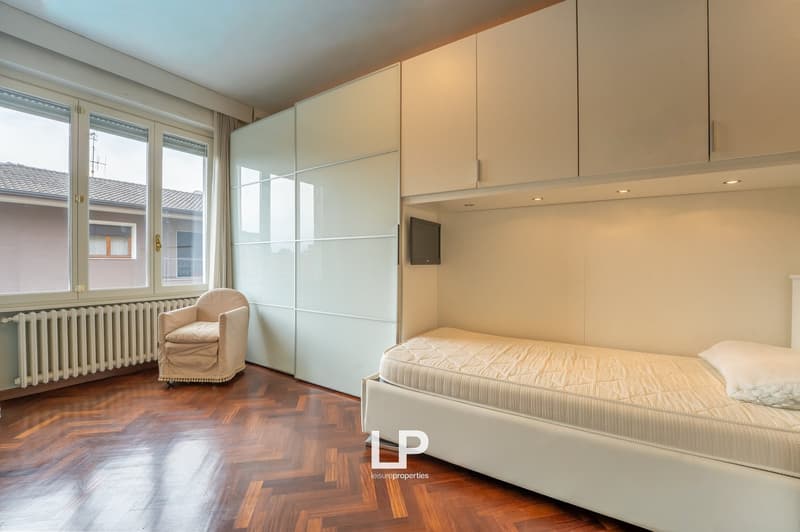 single bed, chair, radiator, large windows, parquet floor