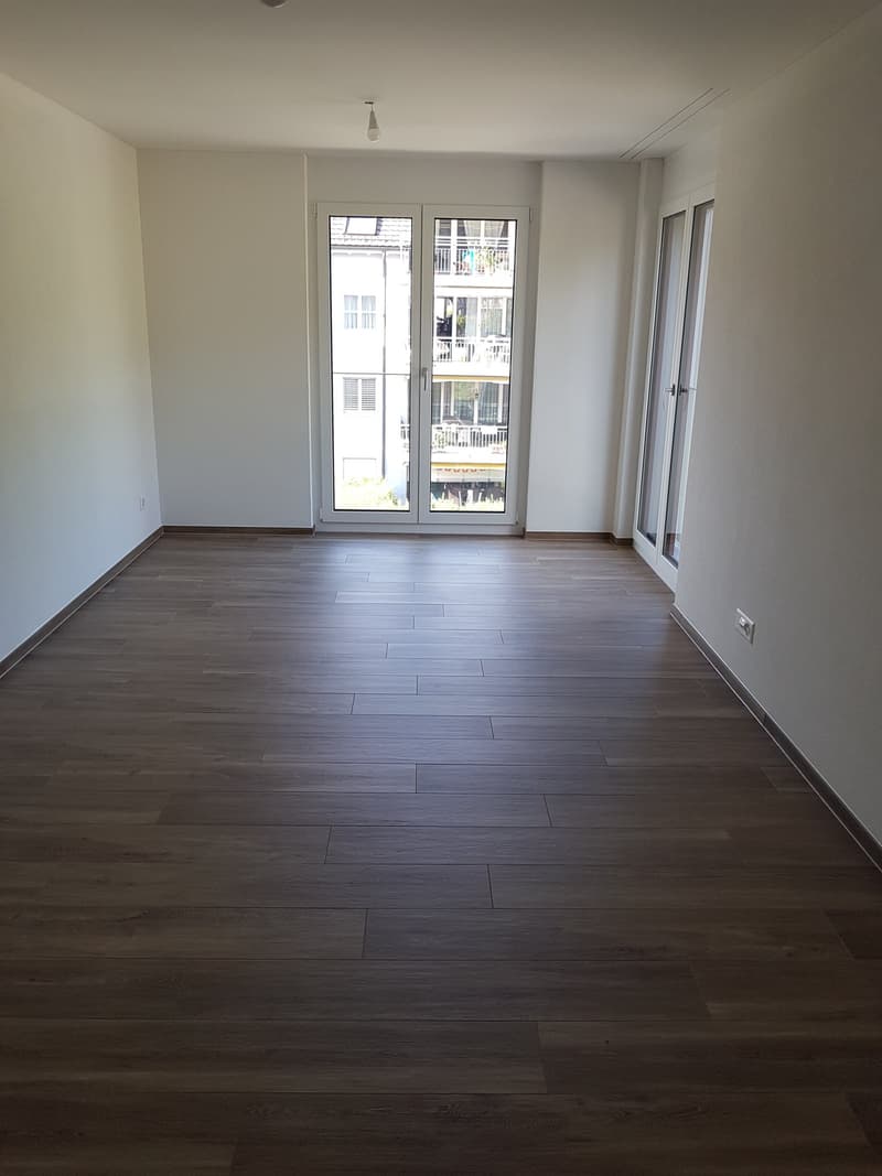 Helles Schlafzimmer mit Glasschiebetüren und Zugang zu Außenbereichen