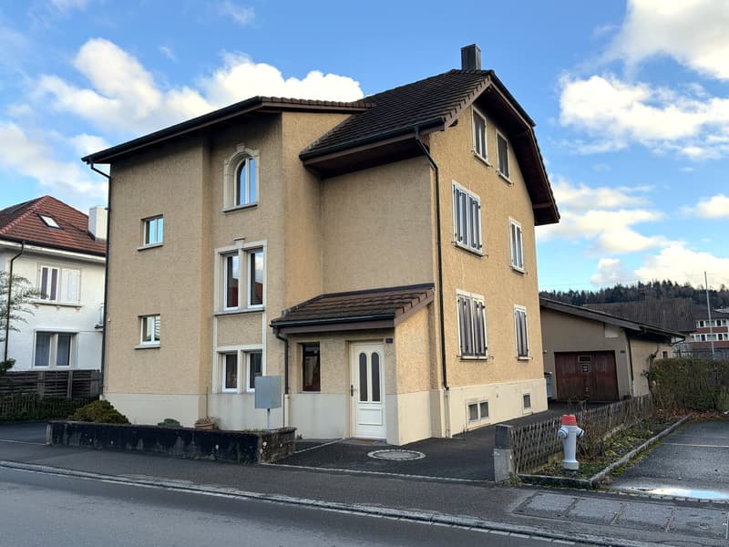 3 story house, beige exterior, white windows, brown roof, garage, parking place
