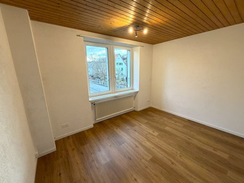 empty room, wooden floor, white walls, wooden ceiling, window with white frame, white radiator