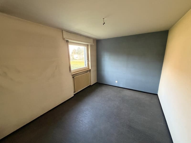 empty room, white and blue walls, window, radiator, black floor