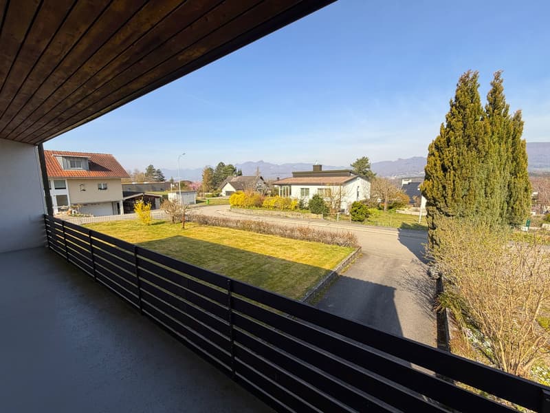 balcony with railing, view of a grassy area and houses