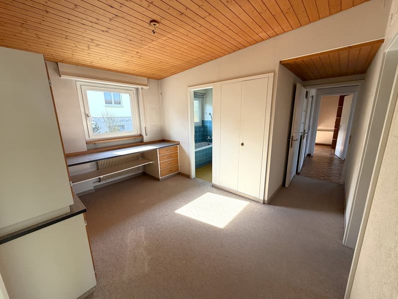empty room, wooden ceiling, white walls, desk, drawers, window, radiator, open doors