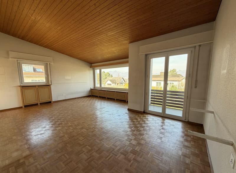 empty room, wooden parquet floor, wooden ceiling, large windows, balcony