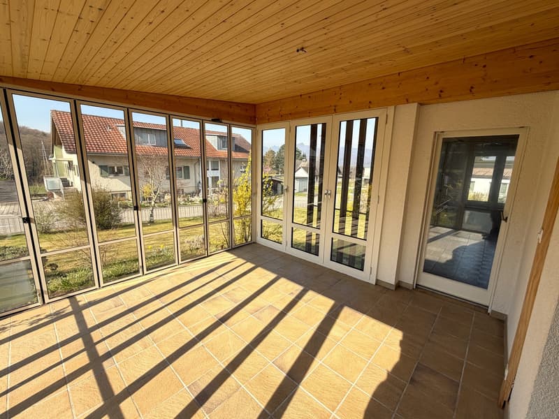 sunny room with large windows, wooden ceiling, tiled floor, view of the outside