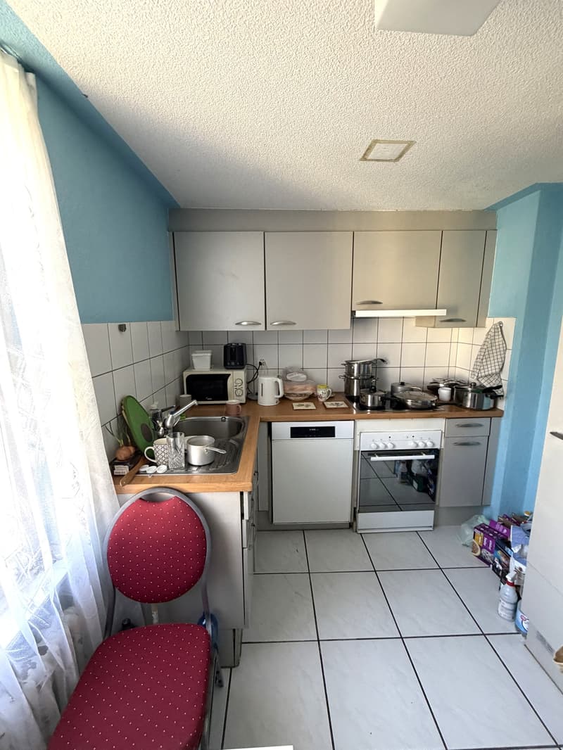 kitchen with white tiles, white cabinets, sink, oven, microwave, refrigerator, and various kitchenware