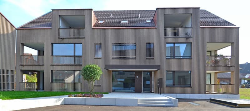 modern design, brown exterior, large windows, balconies, entrance with steps, small garden