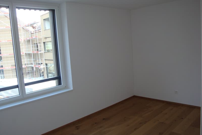 Empty room with white walls, large window, and hardwood floor