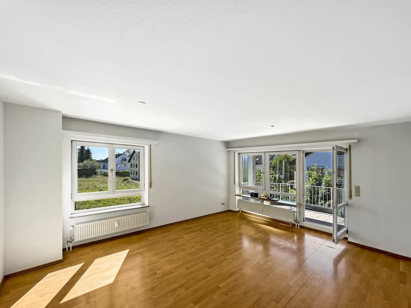 helles Wohnzimmer mit direktem Zugang zum Balkon mit Sicht ins Grüne