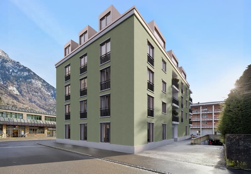 3 story building, green exterior, white trim, balcony in front and back of the building
