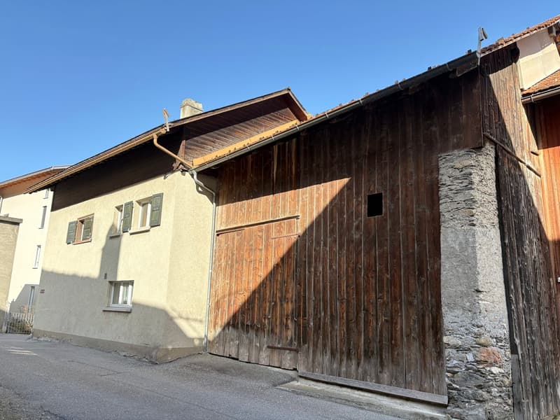 2 story stone and wood house, large wooden garage door, 4 windows