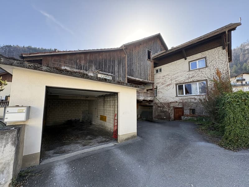 Large house with wooden upper floor, brick lower floor, attached garage, driveway, multiple windows