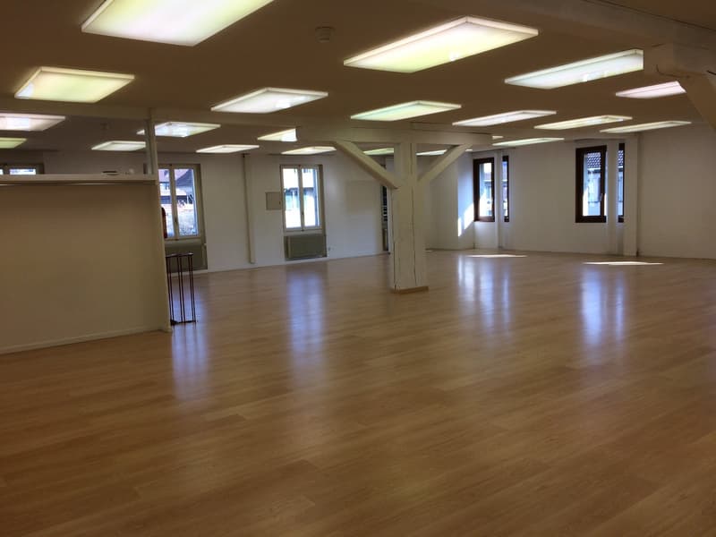 empty large room with wooden floors and ceiling lights