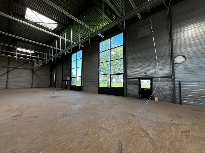 large open space, metal walls, large windows, wooden floor, metal beams