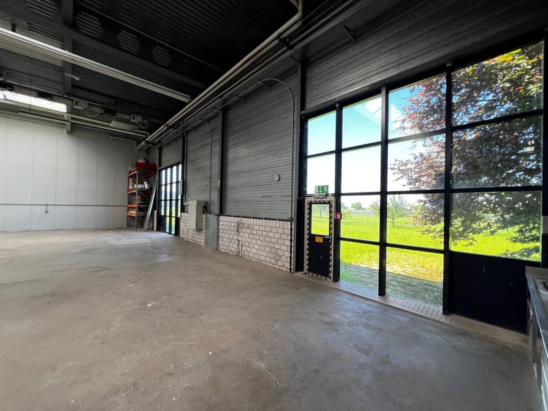 Empty room with concrete floor, metal ceiling, large windows, and a door leading to an outdoor area.