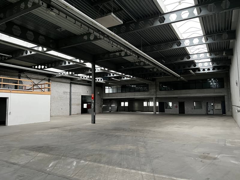 large open space, metal beams, brick walls, glass windows, metal doors, metal scaffolding