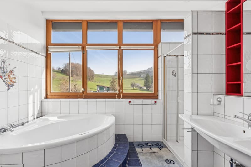 Das Familienbad ist mit einer Dusche und einer Eckbadewanne mit Sprudelfunktion ausgestattet
