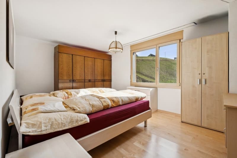 Das Schlafzimmer überzeugt mit einem ruhigen Ambiente und einem eleganten Ausblick ins Grüne  - ideal für erholsame Momente