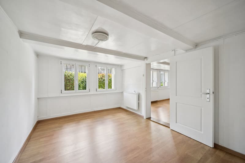 Helles und grosszügiges Zimmer mit Blick in den Garten und nach Süden, das eine freundliche, lichtdurchflutete Wohnatmosphäre schafft