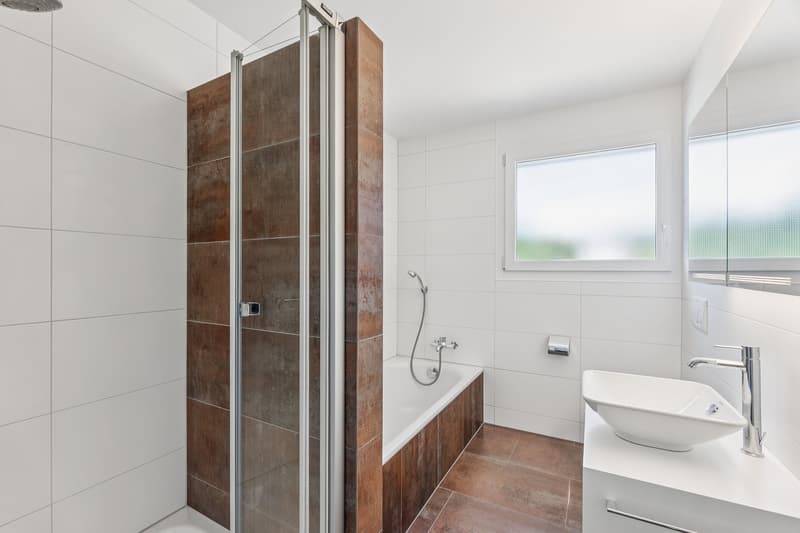 Stilvolles, gepflegtes, modernes Badezimmer mit Dusche und Badewanne.
