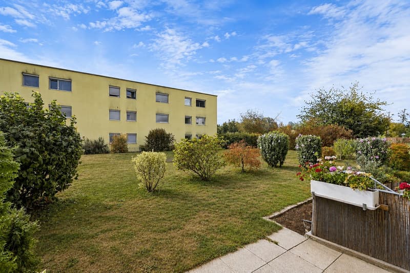 Der gedeckte Sitzplatz mit angrenzendem Garten lädt zum Entspannen und Geniessen im Freien ein.