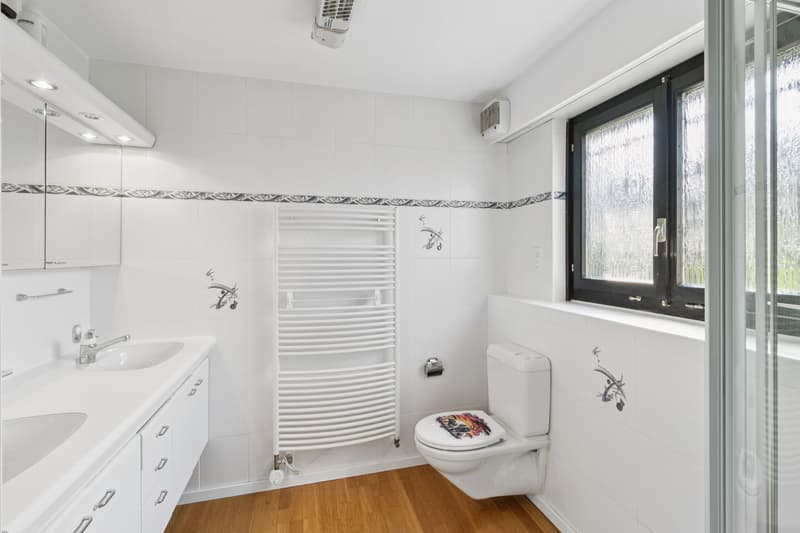Helles Badezimmer mit Fenster und zeitloser Ausstattung