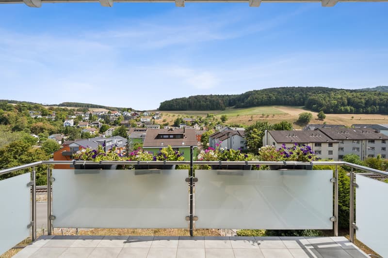 Der Balkon des Wohnzimmers begeistert mit einer attraktiven Tal- und Weitsicht über die umliegende Landschaft